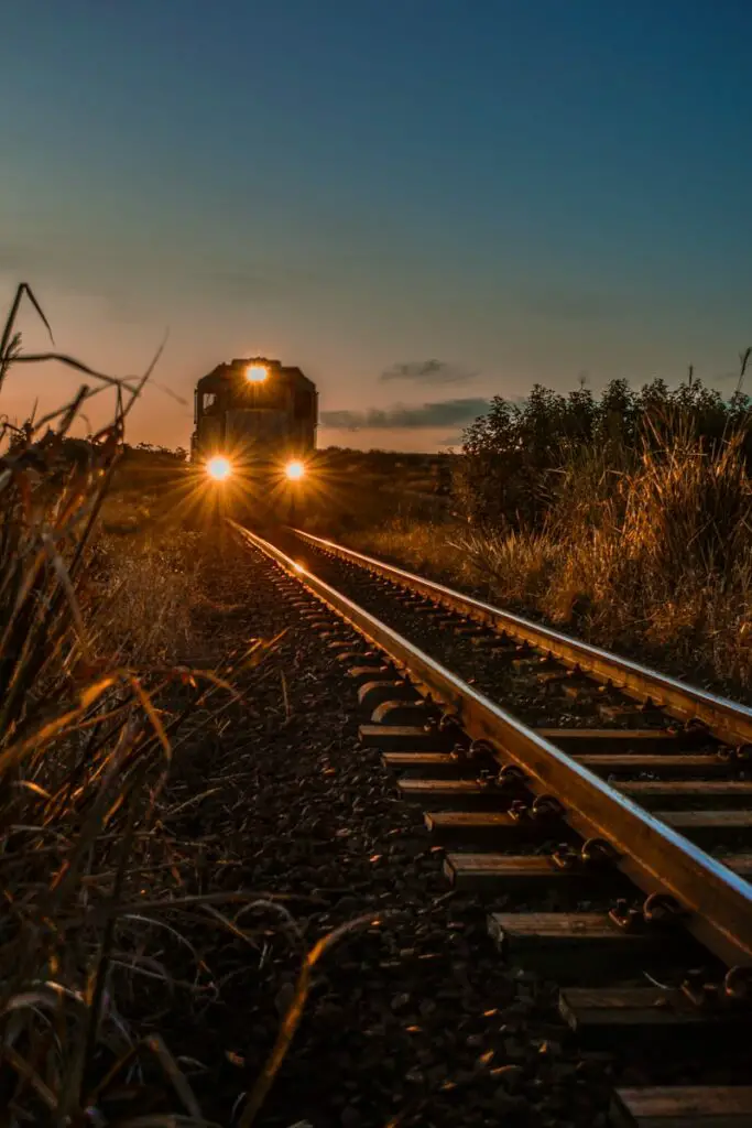 train on rail during sunset railway meaning