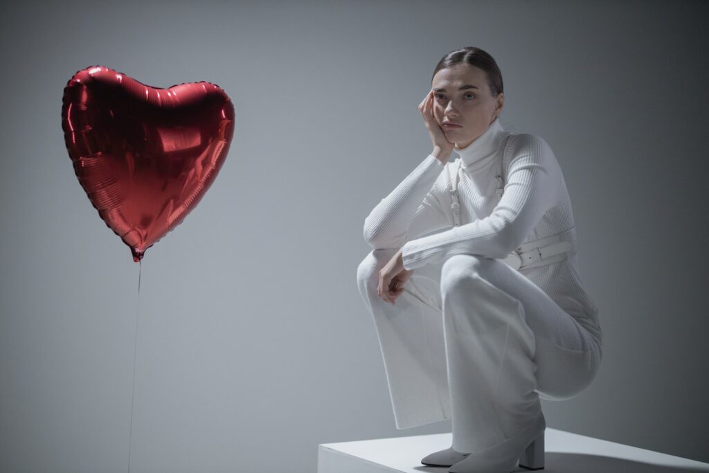 Woman in White Long Sleeve Shirt Holding Heart Balloon